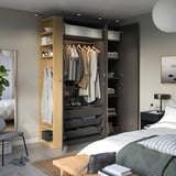 Modern bedroom with a PAX wardrobe showing storage for clothes, folded items, and shoes; open layout displays organizing sections.