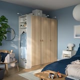 Modern kids bedroom with wardrobe, blue bed, toy train, plant.