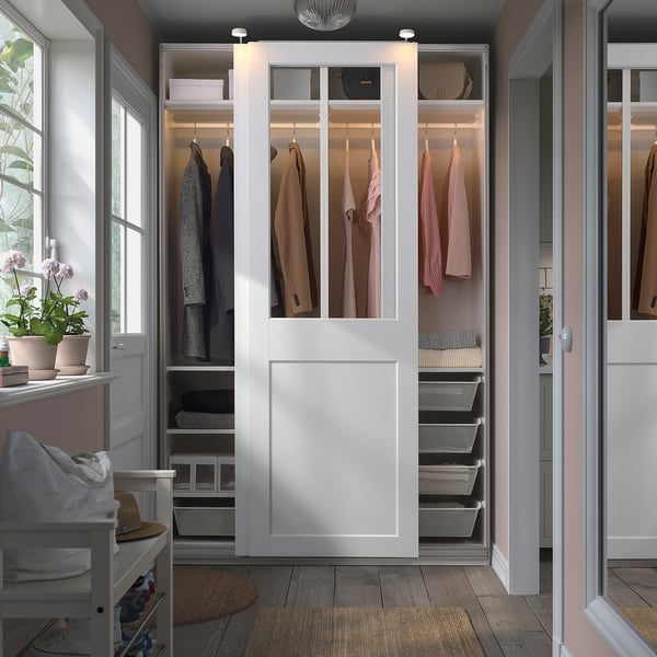 Modern white PAX wardrobe with glass doors and greenery.