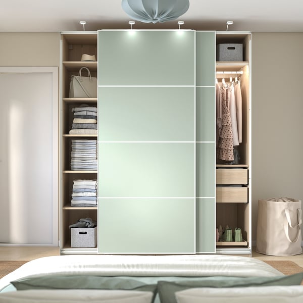 Modern wardrobe with sliding doors, shelves, and a hanging rod. Lighting and drawers for organized storage.