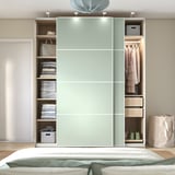 Modern wardrobe with sliding doors, shelves, and a hanging rod. Lighting and drawers for organized storage.