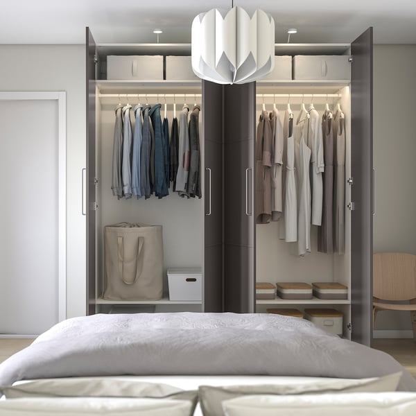 Modern bedroom with open wardrobe: clothes on hangers, shelves, and bags on floor. Soft closing doors, adjustable feet.