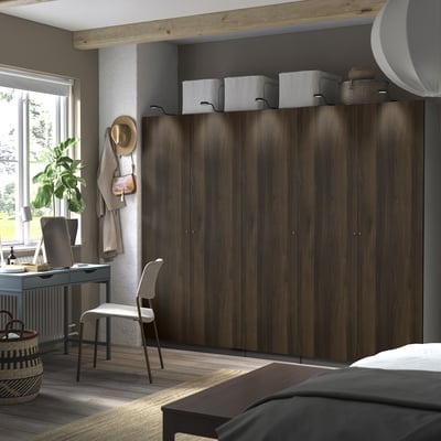 Modern bedroom with dark PAX wardrobes, white boxes, desk, chair, plant & bed.