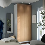 Modern bedroom with PAX wardrobe, mirror, bed & city poster.