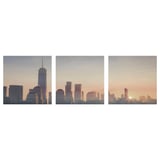 Three-cityscape canvases showcase urban skylines at dusk, framed in white.