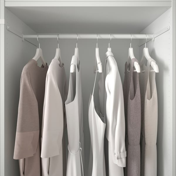 A neatly organized closet with several hanging sweaters on hangers, showcasing PLATSAs simple and efficient storage solution.