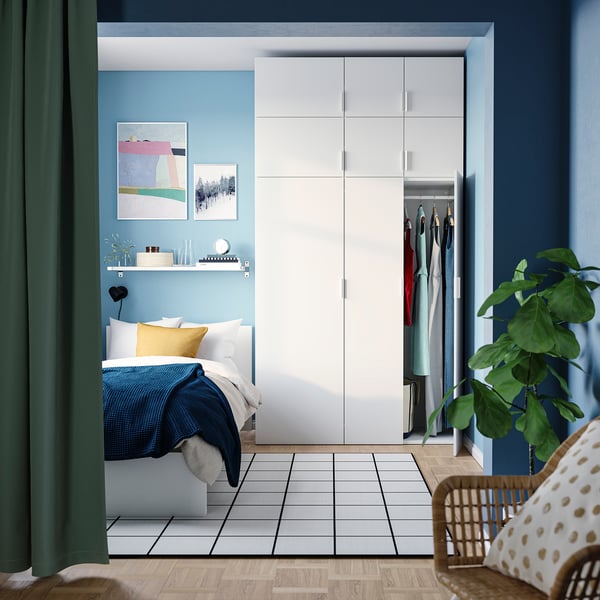 Modern blue bedroom with PLATSA wardrobe and bed, plant.