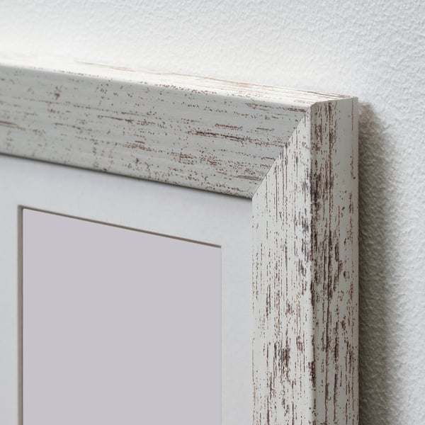 Close-up of PLOMMONTRÄD white distressed frame, textured design, sturdy construction.