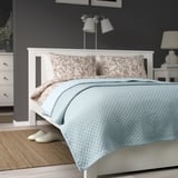 Blue quilted bedspread on double bed, polyester/cotton, soft & warm.