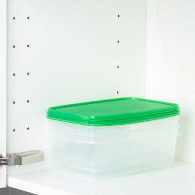 Clear plastic food container with green lid on shelf, stacks & shows contents.
