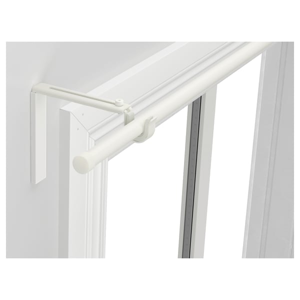 White racka curtain rod, adjustable, mounted near window, includes finials, made of steel and plastic.