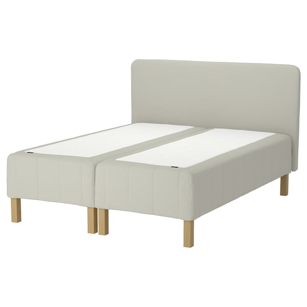 IKEA RÅHOLMAR bed in white with upholstered headboard and wooden legs.