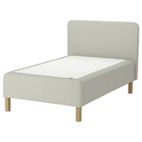 RÅHOLMAR bed in white. Light grey headboard, wooden legs, beige mattress.