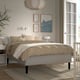 Modern bedroom RÅHOLMAR bed with neutral geometric linens. Wooden frame, wall art, and nightstands. Large, well-aligned.