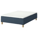 RÅHOLMAR bed base. Rectangular, blue fabric, wooden legs. Topped with a white mattress.