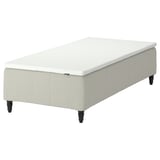 An IKEA RÅHOLMAR bed base in white with wooden legs, designed for supportive and comfortable sleep.