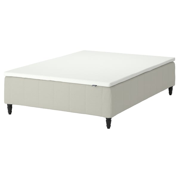 An IKEA RÅHOLMAR bed base in white with wooden legs.