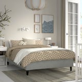 Modern bedroom with RÅHOLMAR bed, patterned bedspread, central chandelier, minimalist decor, and large window.