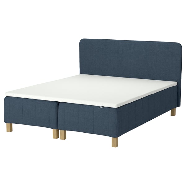RÅHOLMAR bed in blue fabric with memory foam mattress and wooden legs.