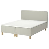 The IKEA RÅHOLMAR bed in white, featuring a padded headboard and wooden legs.