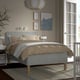 Modern bedroom with gray RÅHOLMAR bed, patterned beige bedding, gray headboard, wall art, and white nightstand.