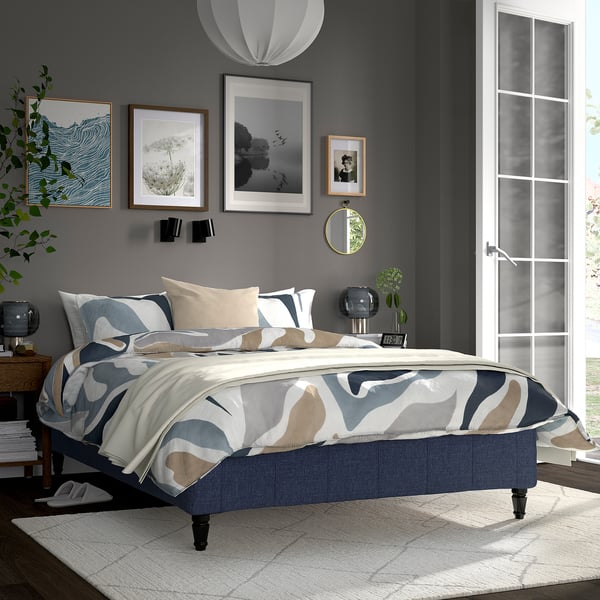 Gray RÅHOLMAR bed, abstract comforter, dark room, plants, art, mirrored door.
