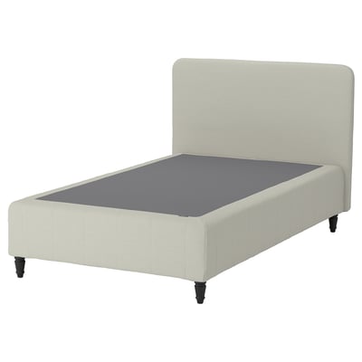 A beige upholstered bed with a high headboard, raised on black wooden legs.