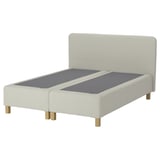 A RENFJÄLLET bed in white with a padded headboard and wooden legs. The design a modern, clean look.