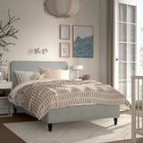 Light gray RENFJÄLLET bed with headboard, footboard, rug, beige blanket, white pillows, nightstand, crib, artwork, chandelier.