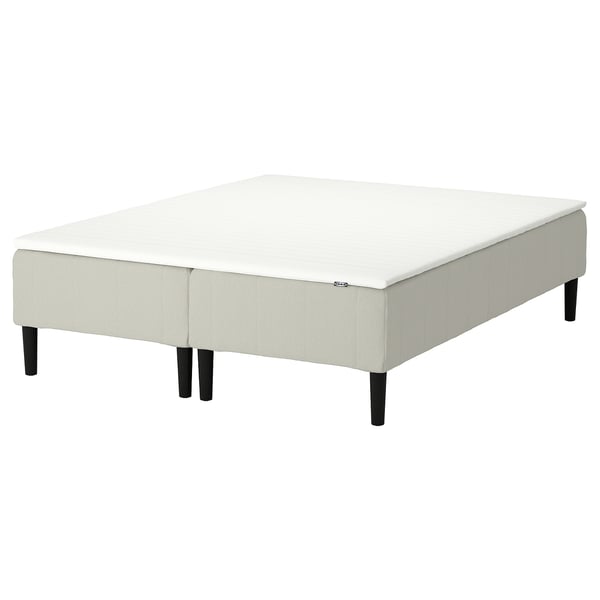 White upholstered platform bed with wooden legs.