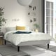 Modern bedroom with white RENFJÄLLET bed, striped rug, yellow accents, abstract art.