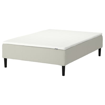White rectangular upholstered ottoman, four dark wooden legs, plush fabric.
