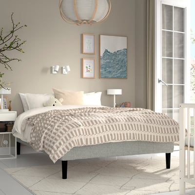 Modern bedroom with RENFJÄLLET bed, neutral colours, plaid bedspread, nightstands, artwork.