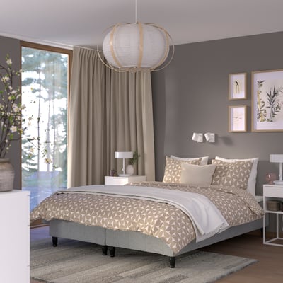Small gray bedroom with large bed, cute pendant lamp, wooden nightstands, and a large window.