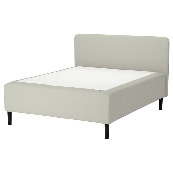 A white RISHÖJDEN bed with a padded headboard and black legs. Its a modern, minimalist design.