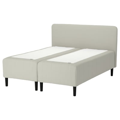 RISHÖJDEN bed: beige, upholstered base with wooden legs, attached headboard, minimalist design.