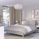 Grey RISHÖJDEN king bed, 7-zone mattress, patterned pillows, large lamp, beige curtains, white walls, nightstands, wall art.