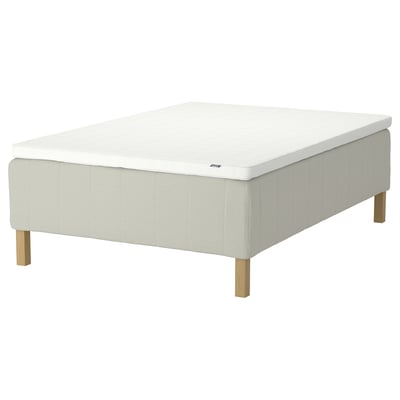 White mattress on base with wooden legs. Modern, minimalist design.
