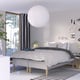 Modern bedroom with RISHÖJDEN bed, white pendant lamp, black/white patterned bedding, gray headboard. Window with tree view.