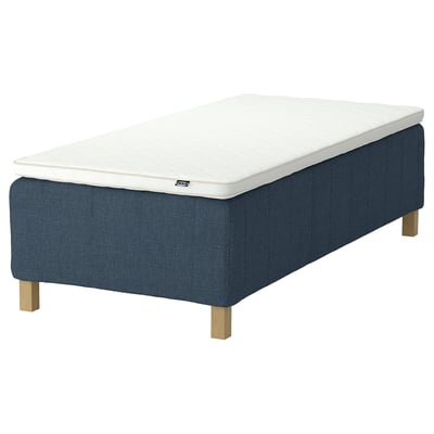 Blue upholstered bed with white mattress, wooden legs, rectangular design.