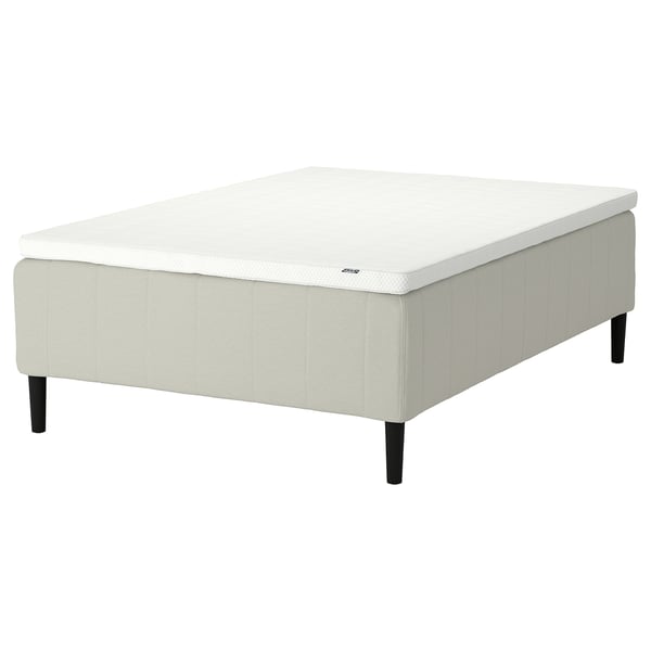 White modern square ottoman with tufted design and black legs.