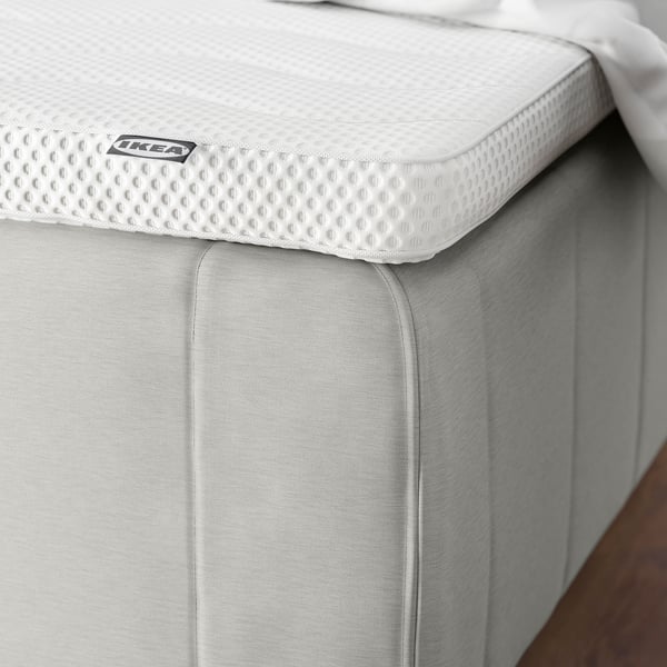 Close-up of a RISHÖJDEN mattress showing its reinforced edge and textured top, highlighting its supportive design.