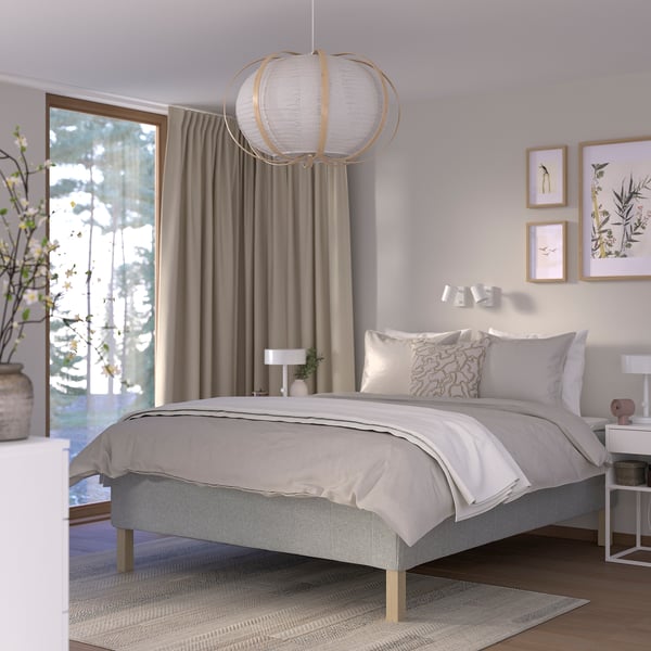 Minimalist bedroom with RISHÖJDEN bed, pendant lamp, grey curtains, rug, nightstands, and wall art.