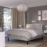 Modern bedroom with RISHÖJDEN bed, light grey, wooden legs. Minimalist design, large window, artwork, pendant light.