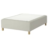 Modern white bed base with wooden legs, upholstered design, sleek and minimalist.