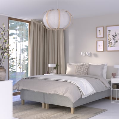 Modern bedroom with RISHÖJDEN bed, grey bedding, spherical lamp, plant bedside table, art, rug.