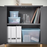 Shelf display of blue and white storage boxes, clear vases, and books. Boxes organize small items, are partly recycled, and semi-transparent.