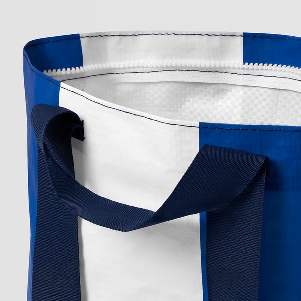 Close-up of blue reusable shopping bag with sturdy handles, showcasing quality fabric and stitching.