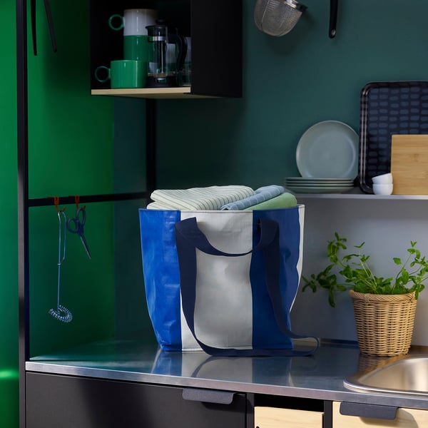 Blue säckkär bag with handle on counter, smaller than folded towels, made of recycled polypropylene.