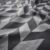 Black and white geometric patterned towel, textured, laid out.